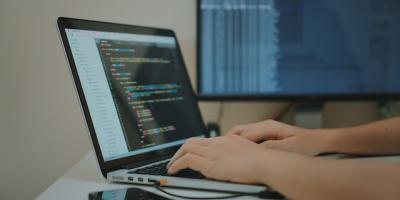 Person coding on laptop at a desk